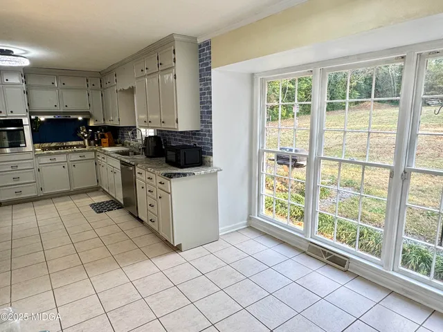 a kitchen with granite countertop a stove microwave and cabinets