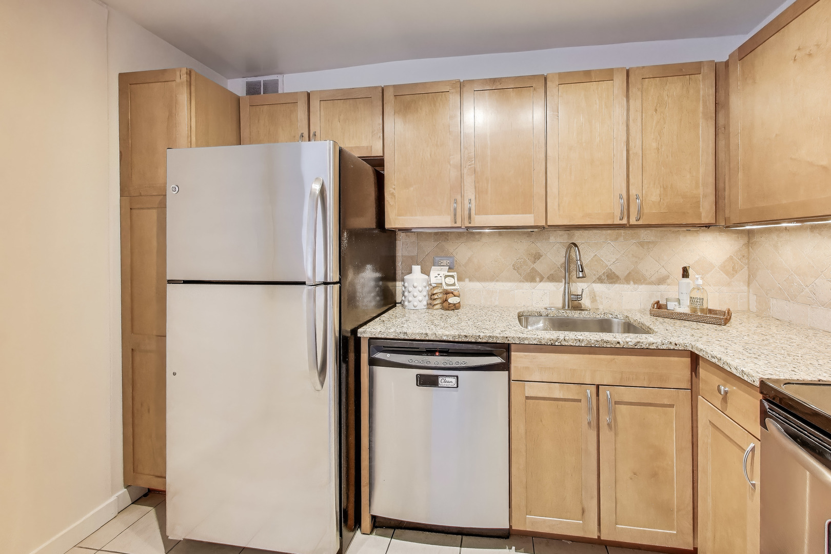 655 West Irving Park Road, Unit 606 Chicago, IL 60613 - Photo 11 of 29 a kitchen with a sink a refrigerator a washer and dryer