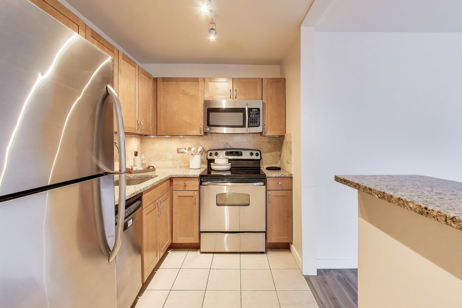 655 West Irving Park Road, Unit 606 Chicago, IL 60613 - Photo 12 of 29 a kitchen with a refrigerator a stove top oven and cabinets