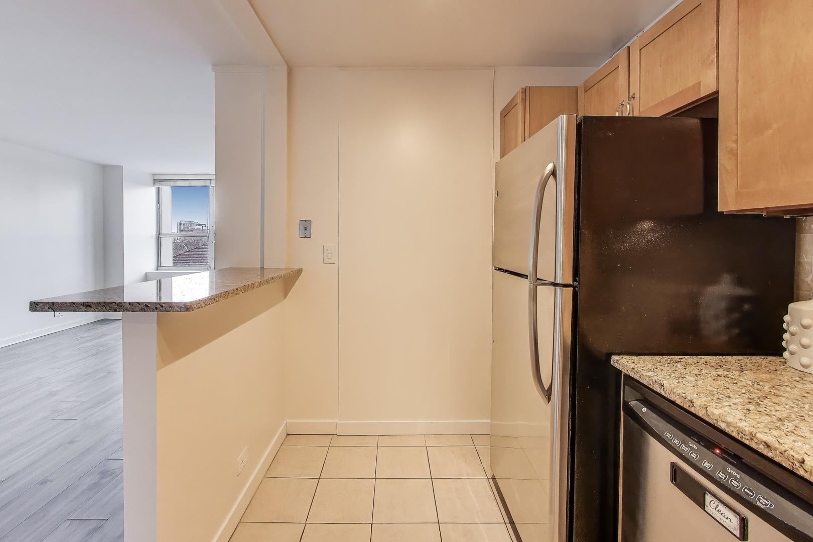 655 West Irving Park Road, Unit 606 Chicago, IL 60613 - Photo 13 of 29 a view of a kitchen with a refrigerator and a stove