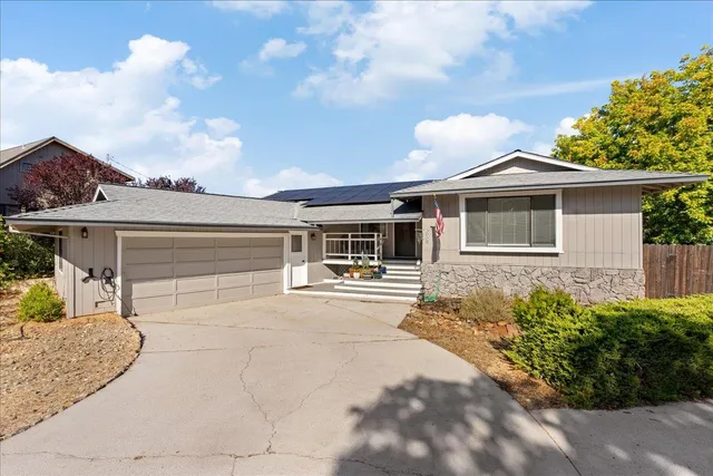 a front view of a house with a yard and potted plants