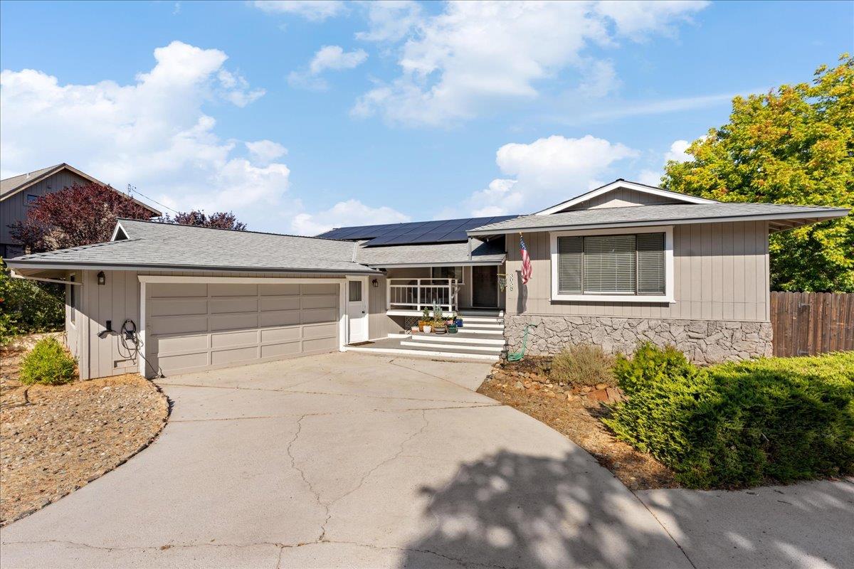 a front view of a house with a yard and potted plants