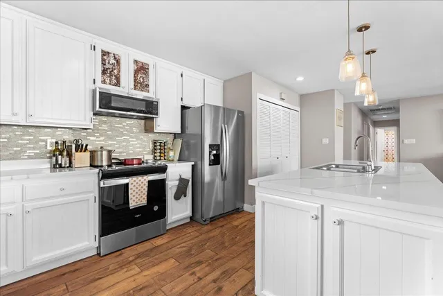 a kitchen with stainless steel appliances granite countertop a refrigerator sink and stove