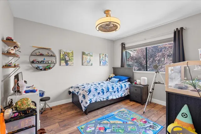 a bedroom with a bed and a wooden floor