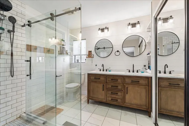 a spacious bathroom with a double vanity sink toilet and shower