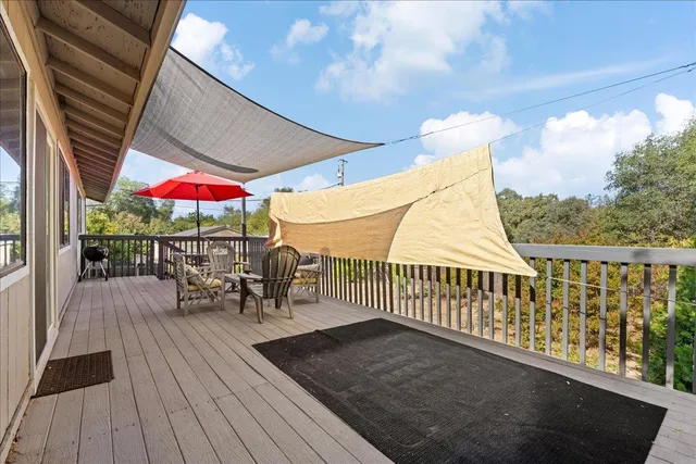 a view of a patio with a table and chairs under an umbrella
