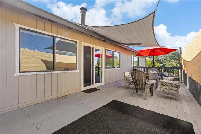a view of deck with table and chairs under an umbrella with wooden floor