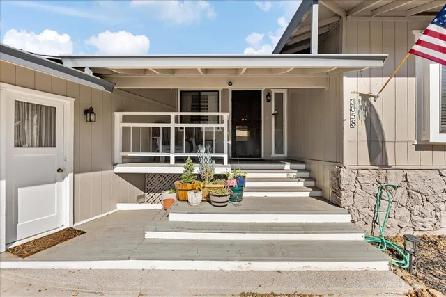 a view of a patio with table and chairs with wooden floor and fence
