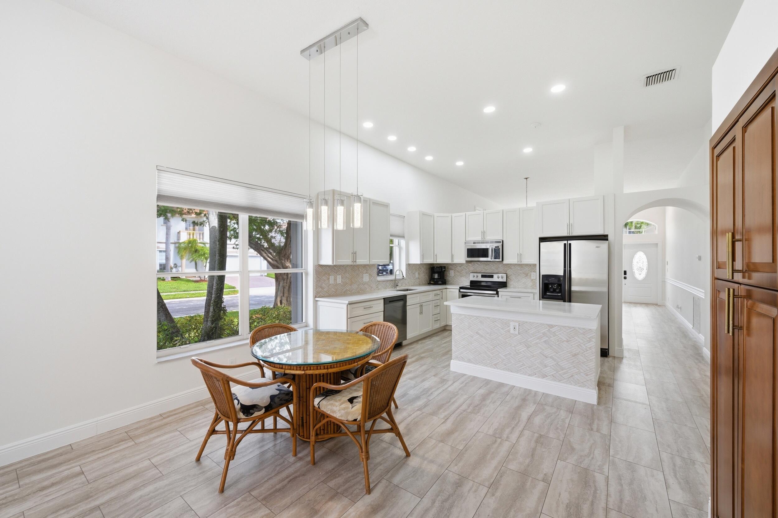 8534 Vía D Oro Boca Raton, FL 33433 - Photo 15 of 34 a kitchen with a dining table chairs and refrigerator