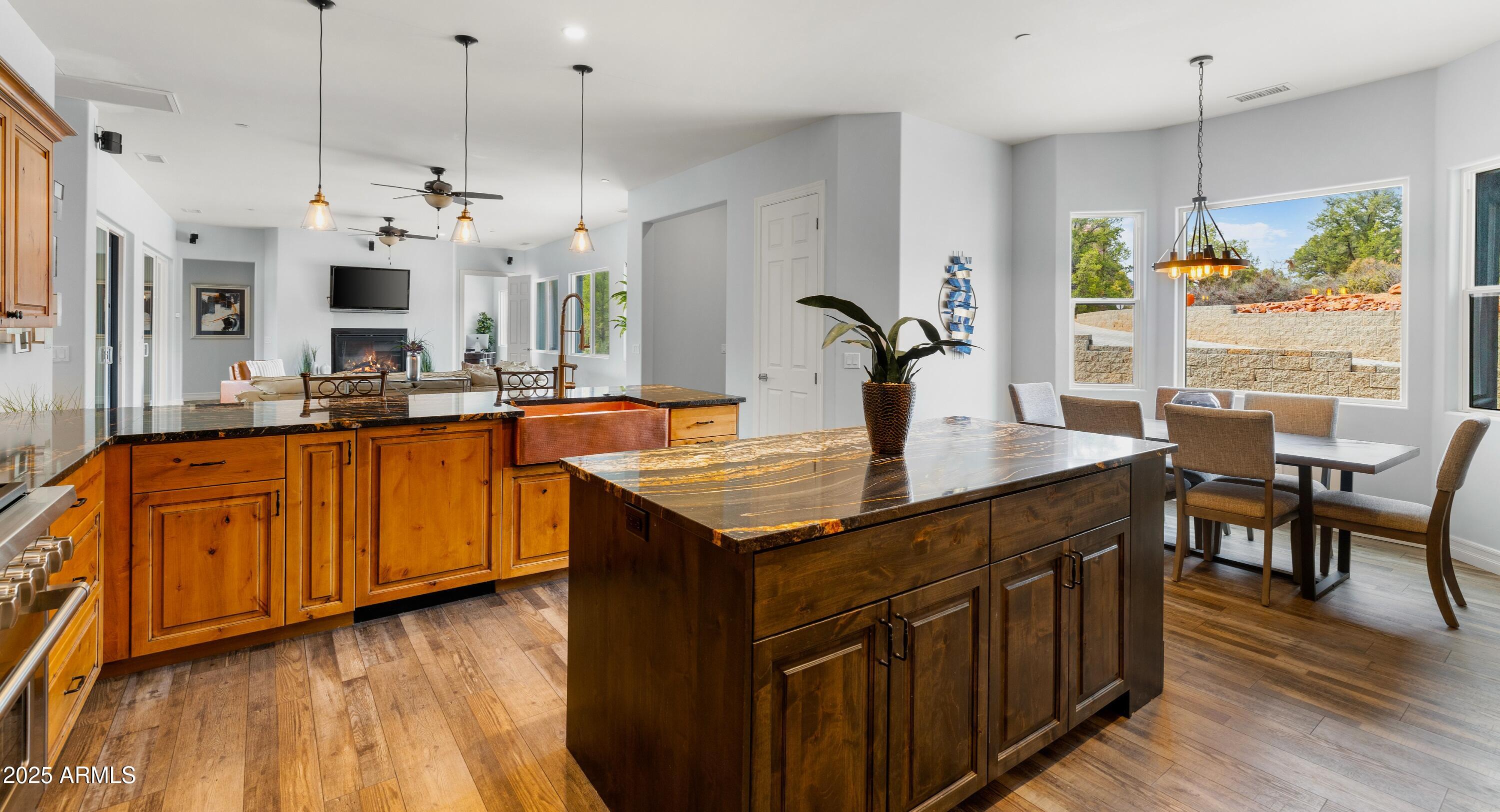 10 Ho Hum Circle Sedona, AZ 86351 - Photo 19 of 48 a kitchen with kitchen island granite countertop a stove a sink a center island and living room view