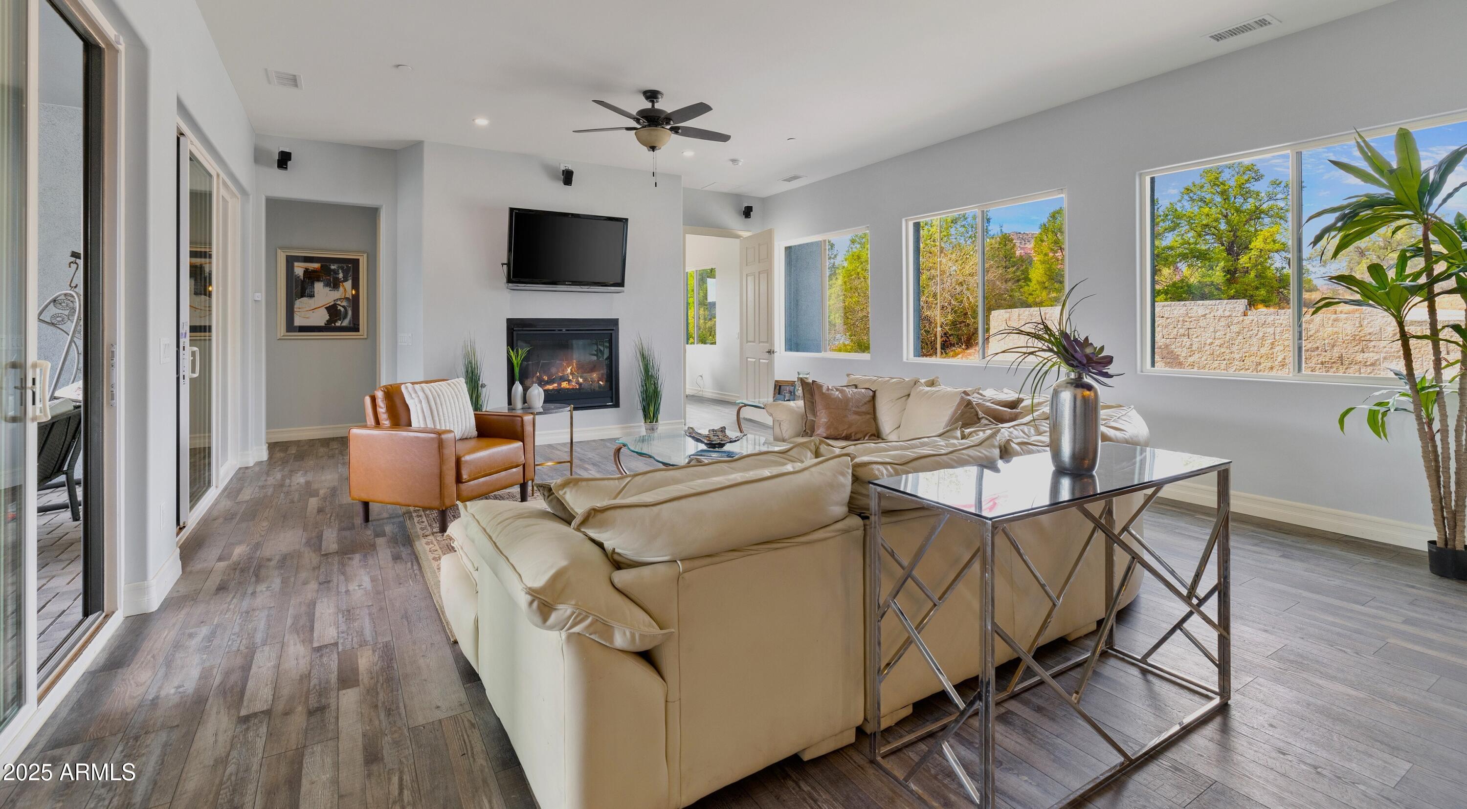 10 Ho Hum Circle Sedona, AZ 86351 - Photo 6 of 48 a living room with furniture a fireplace and a floor to ceiling window