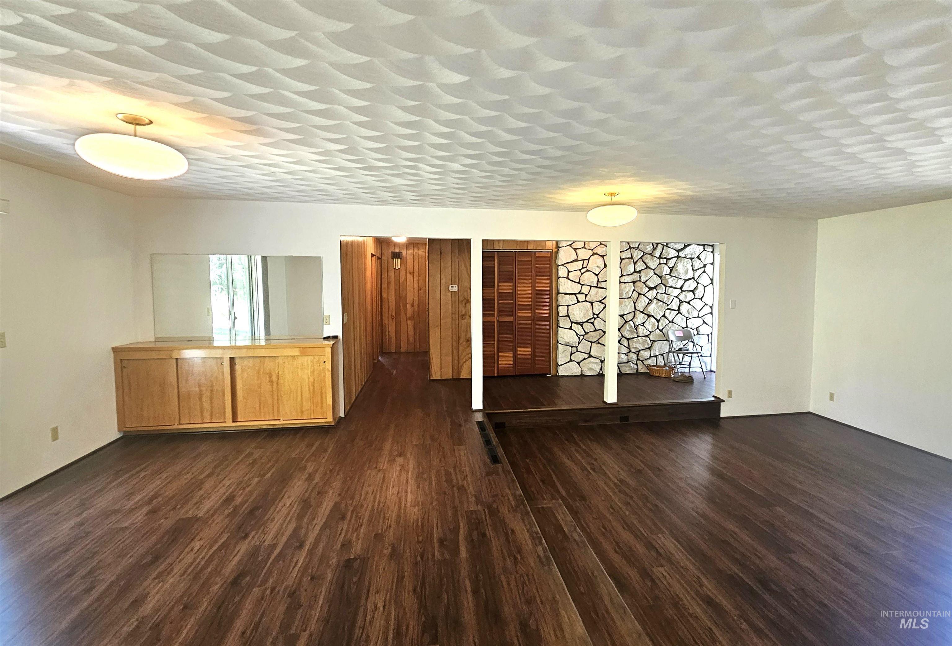 29865 Mission Creek Road Culdesac, ID 83524 - Photo 4 of 43 Spacious interior featuring wood-finish flooring, a textured ceiling, recessed lighting, a built-in wood cabinet with sliding doors, and a stone accent wall