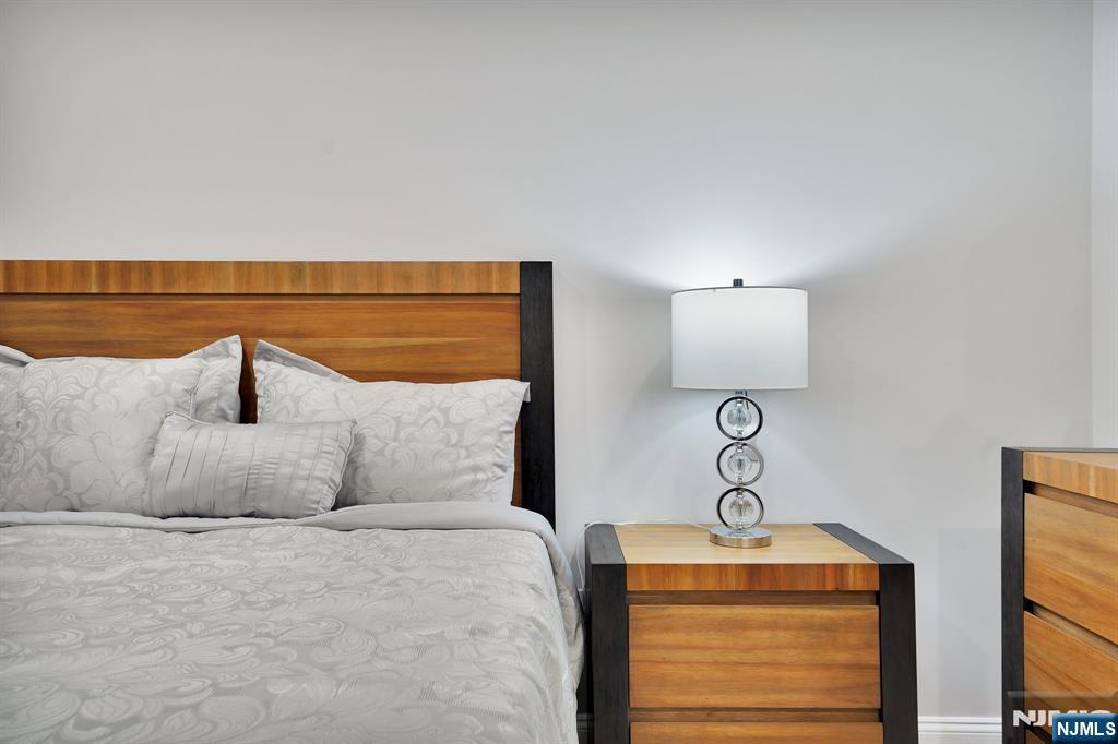 225 South 9th Street Newark, NJ 07103 - Photo 29 of 35 a bedroom with a bed and dresser with mirror