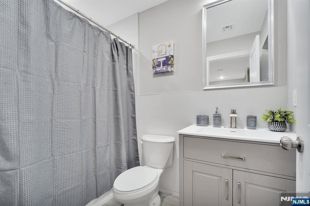 225 South 9th Street Newark, NJ 07103 - Photo 33 of 35 a bathroom with a sink a toilet and vanity