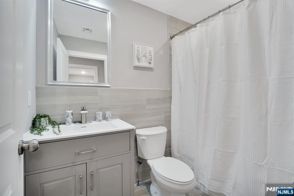 225 South 9th Street Newark, NJ 07103 - Photo 34 of 35 a bathroom with a sink a toilet and a mirror