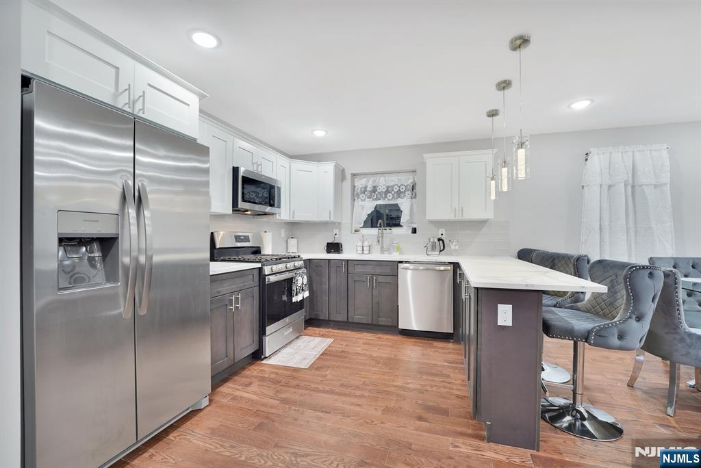 225 South 9th Street Newark, NJ 07103 - Photo 7 of 35 a open kitchen with stainless steel appliances granite countertop a refrigerator a sink dishwasher a stove and a refrigerator with wooden floor