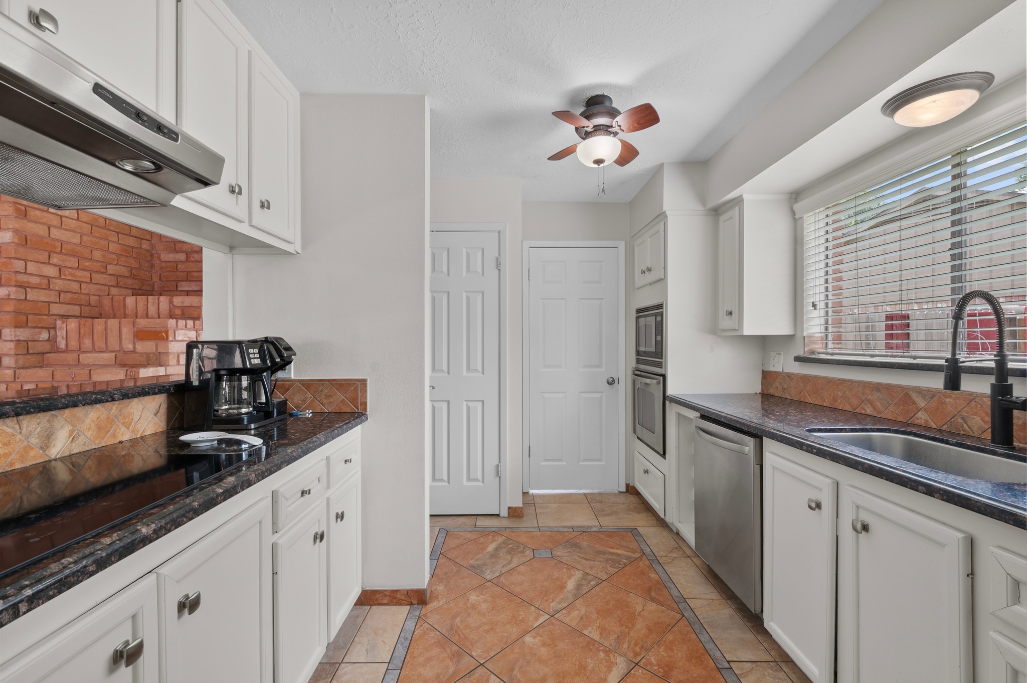 706 Geronimo Court Katy, TX 77450 - Photo 11 of 29 a kitchen with granite countertop a sink stainless steel appliances and cabinets