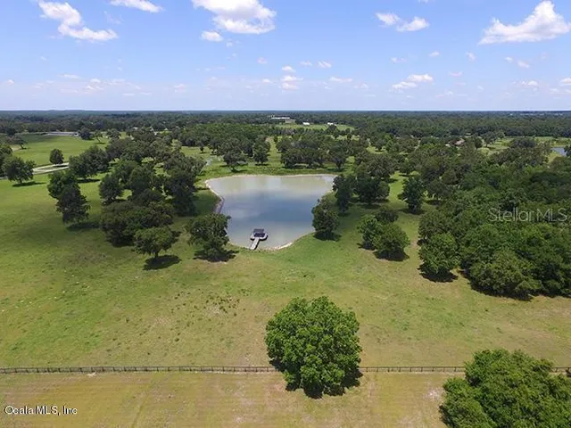 an aerial view of a houses with a yard and lake view