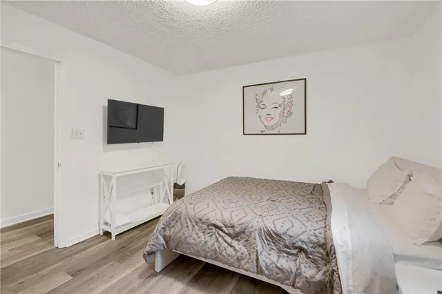 a bedroom with a bed and painting on the wall