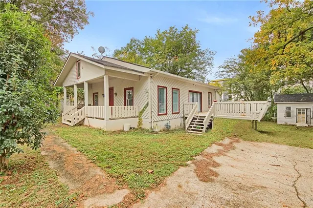 a view of a house with a yard and fence