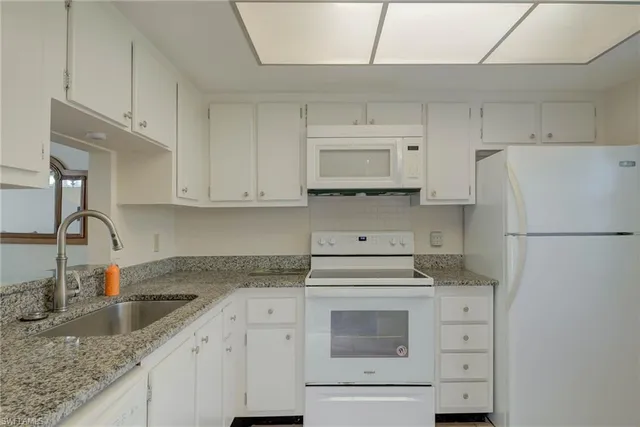 a kitchen with appliances a sink and cabinets