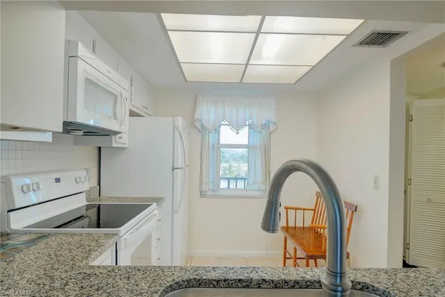 a kitchen with stainless steel appliances granite countertop a sink a stove and a refrigerator