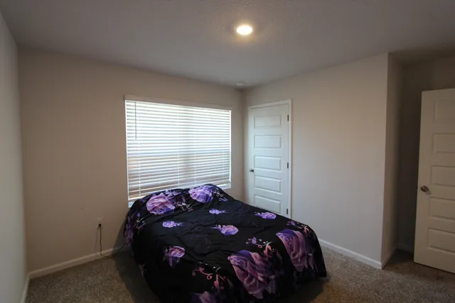 a bed sitting in a bedroom next to a window