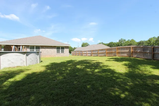 a view of a house with a yard and sitting area