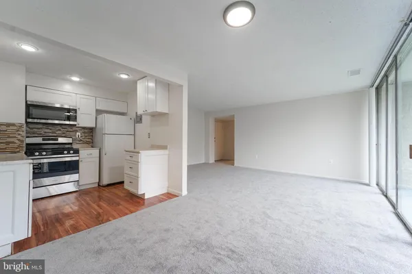 a kitchen with granite countertop white cabinets and stainless steel appliances
