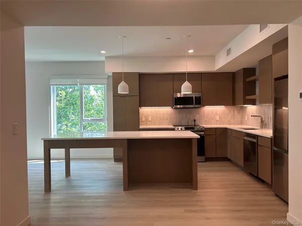 a large kitchen with stainless steel appliances granite countertop a stove and a wooden floors