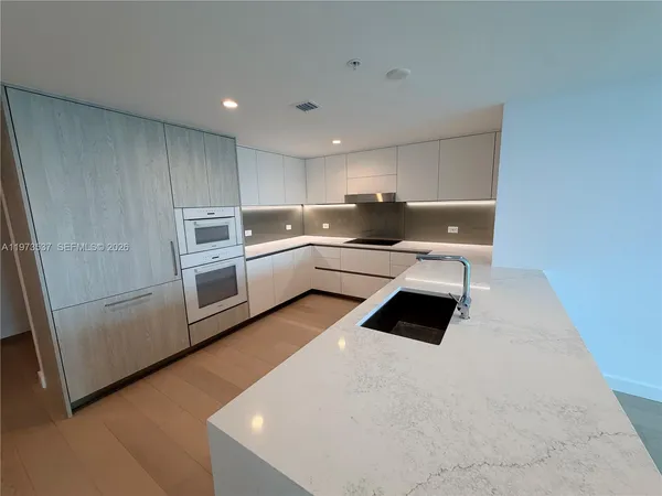 a kitchen with a stove and white cabinets