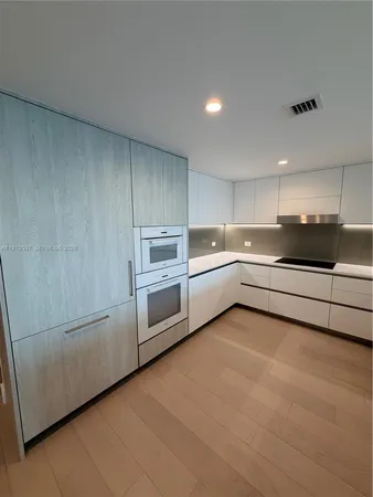 a kitchen with stainless steel appliances a sink a stove a refrigerator and cabinets