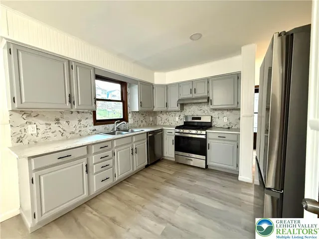 a kitchen with granite countertop white cabinets and stainless steel appliances