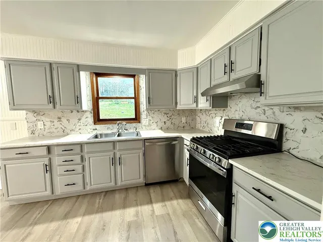 a kitchen with granite countertop white cabinets and a stove