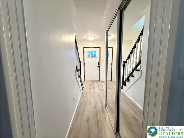 a view of a hallway with wooden floor and staircase