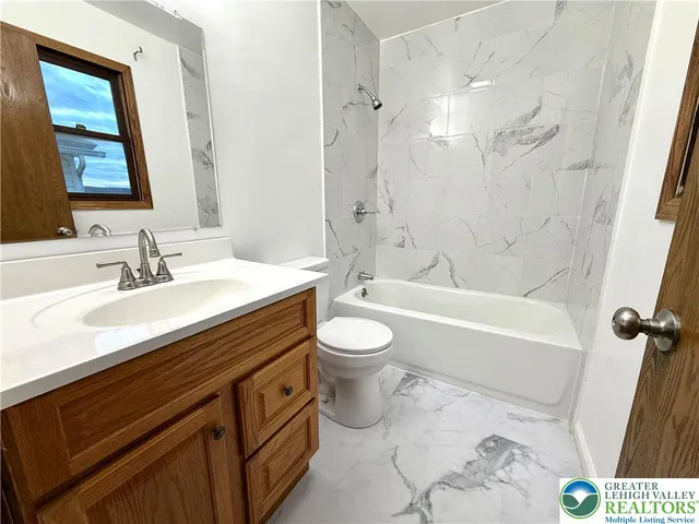 a bathroom with a double vanity sink toilet mirror and bathtub