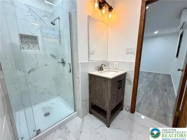 a bathroom with a sink a mirror and shower