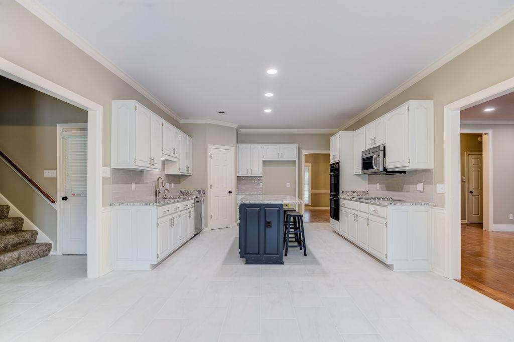 1633 Beckenhall Street Collierville, TN 38017 - Photo 11 of 35 a kitchen with stainless steel appliances kitchen island granite top and refrigerator