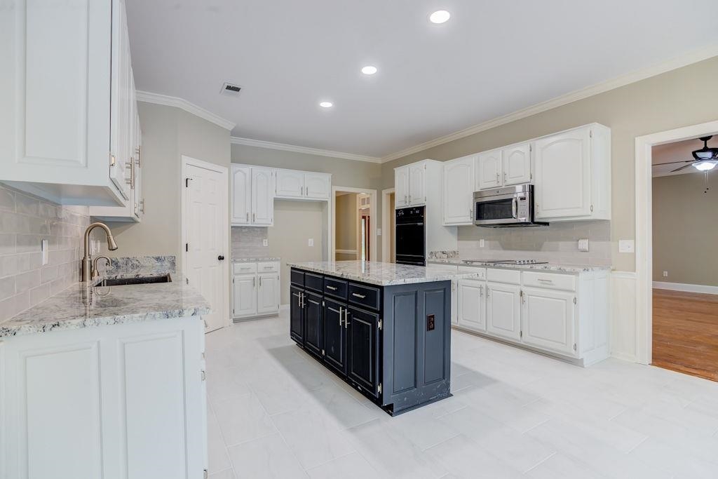 1633 Beckenhall Street Collierville, TN 38017 - Photo 12 of 35 a kitchen with stainless steel appliances granite countertop a stove top oven a refrigerator a sink and dishwasher with white cabinets