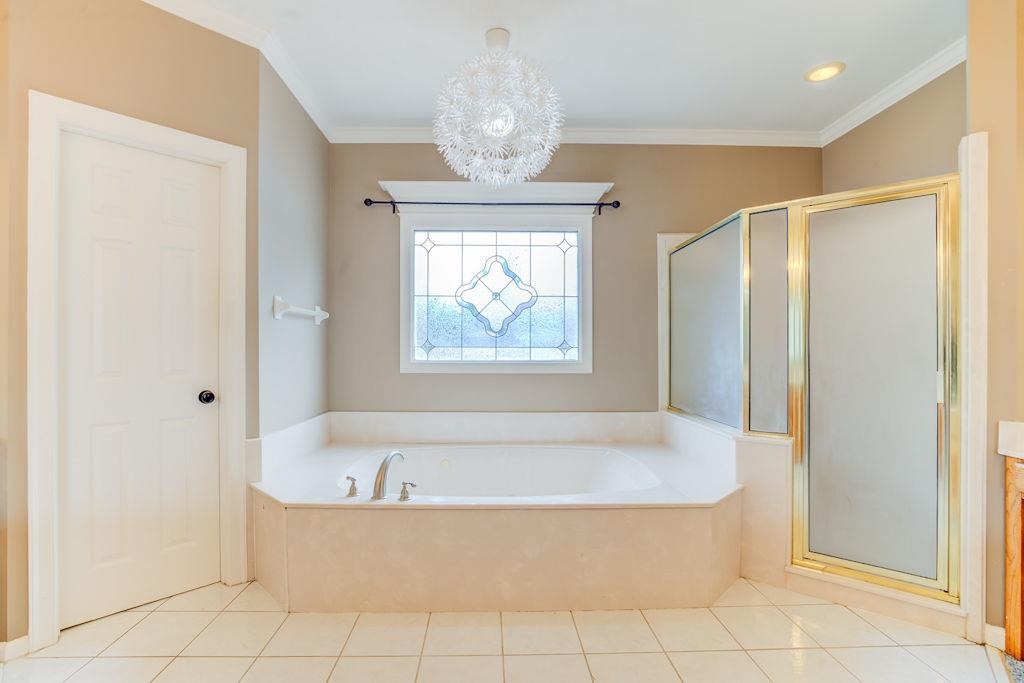 1633 Beckenhall Street Collierville, TN 38017 - Photo 19 of 35 a bathroom with a bathtub and chandelier