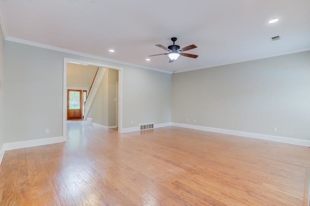 1633 Beckenhall Street Collierville, TN 38017 - Photo 8 of 35 a view of an empty room with wooden floor and a ceiling fan