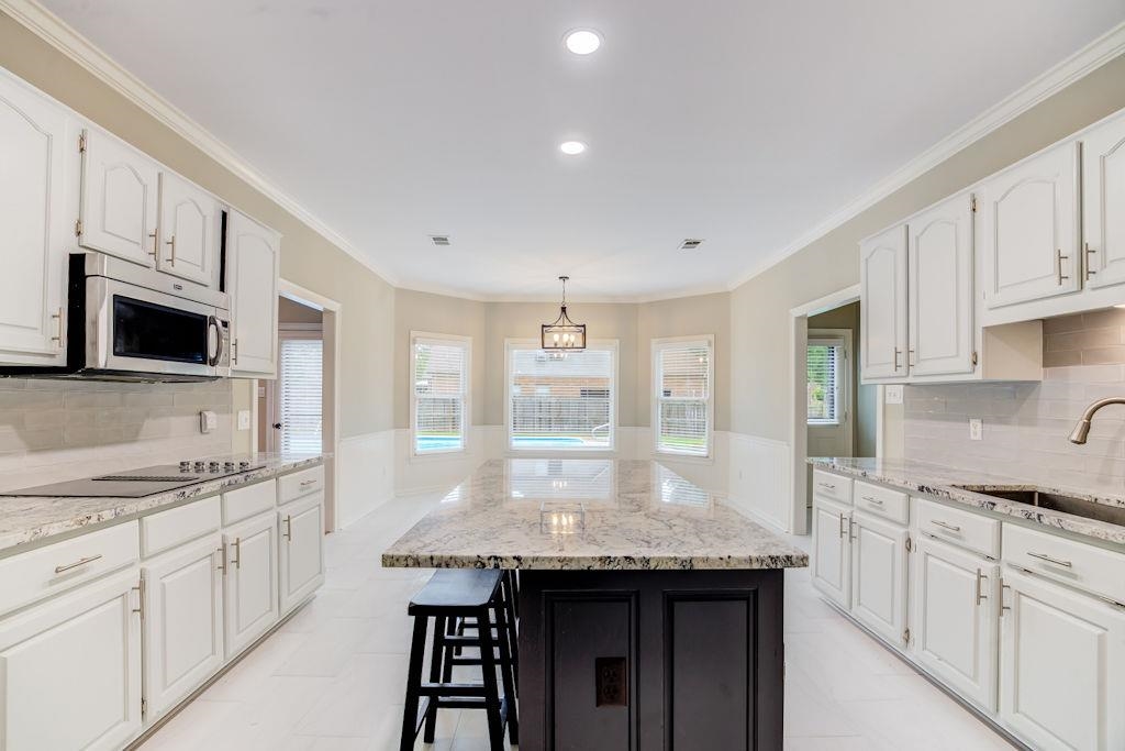 1633 Beckenhall Street Collierville, TN 38017 - Photo 10 of 35 a kitchen with granite countertop kitchen island white cabinets and refrigerator