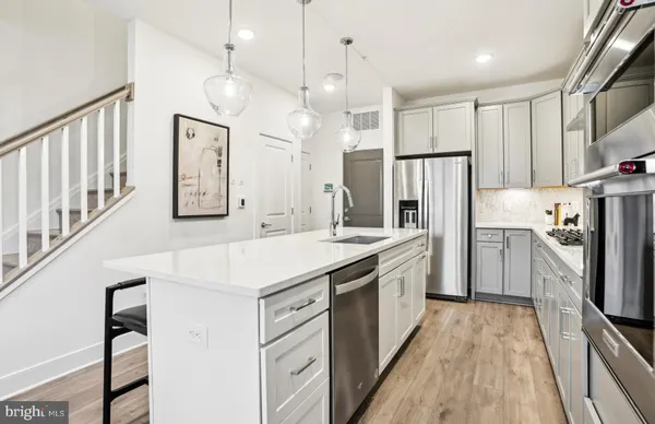 a kitchen with kitchen island a stove a chandelier and a refrigerator