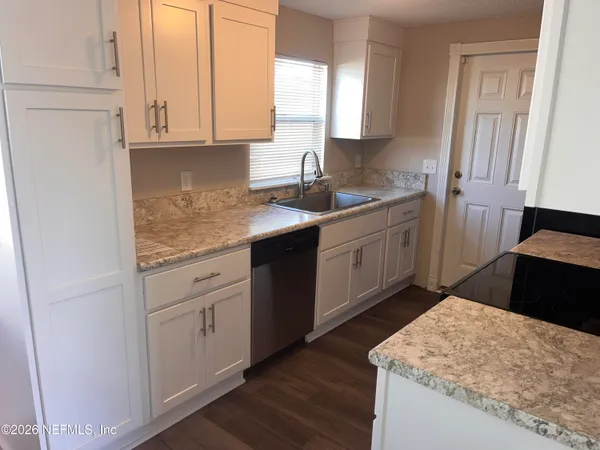 a kitchen with stainless steel appliances granite countertop a sink stove and cabinets