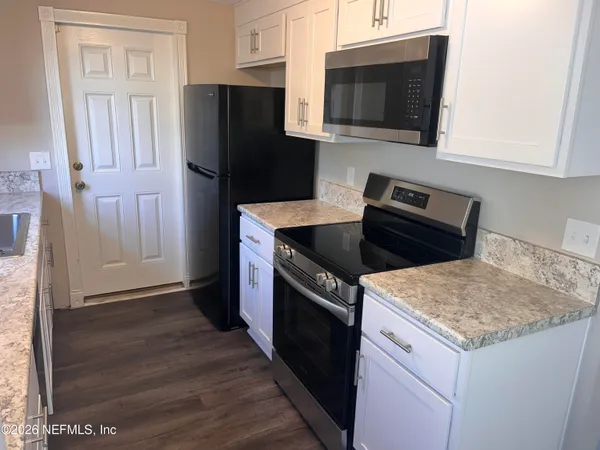 a kitchen with stainless steel appliances granite countertop a refrigerator stove and microwave