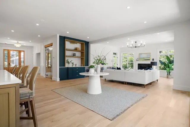 a living room with furniture a table and kitchen view