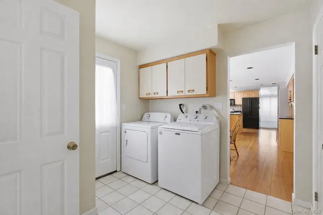 a utility room with cabinets washer and dryer