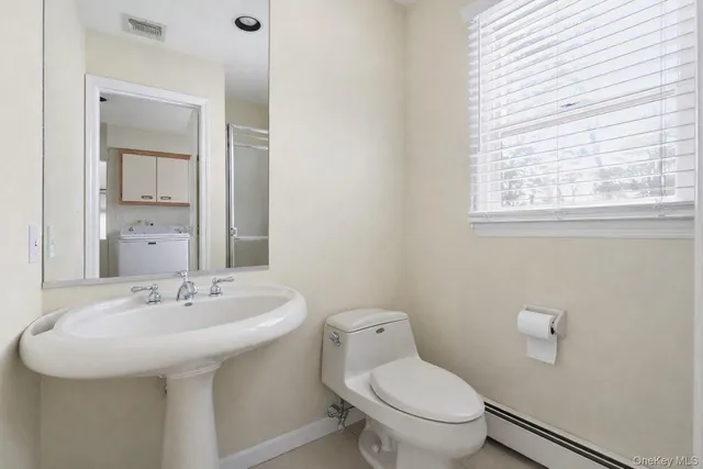 a bathroom with a sink a toilet and a mirror