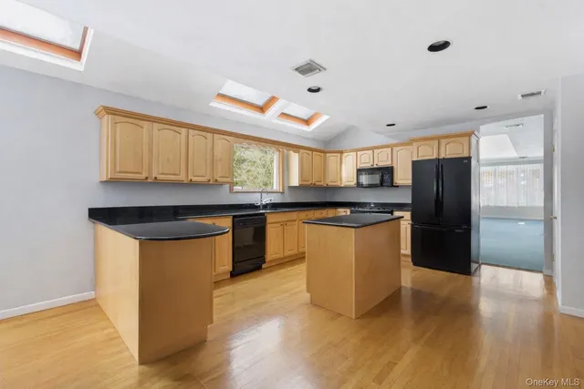 a kitchen with granite countertop a refrigerator and a stove top oven