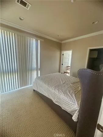 a large bed sitting in a bedroom next to a window